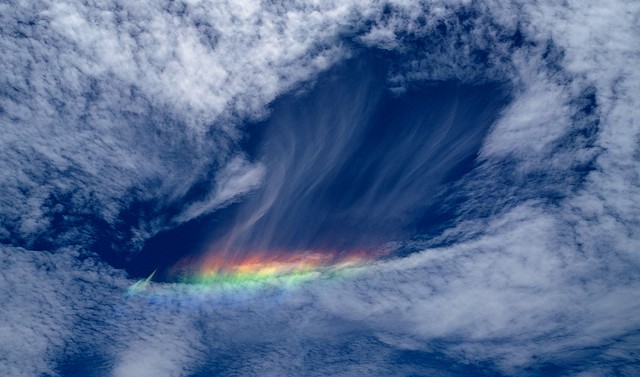 Arco iris de fuego entre nubes cirrus